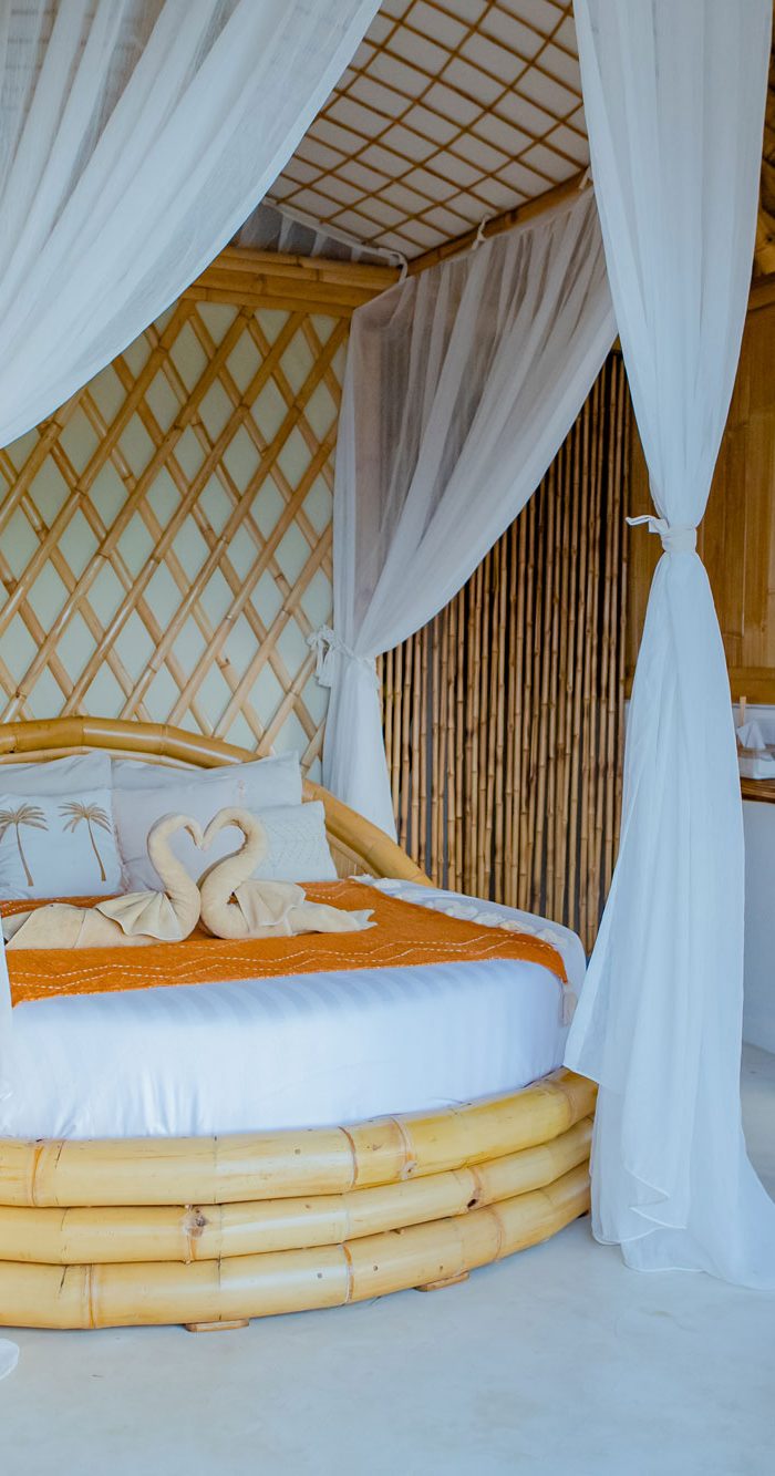 Beautiful bamboo bedroom with round bed and canopy curtains at Camanta Penida villa